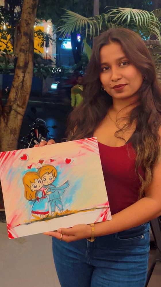 Gunjan holding one of her paintings